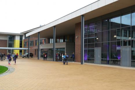 Die Aula im Bildvordergrund und die links daneben liegende Mensa liegen im Zentrum des Schulkomplexes und prägen die Ansicht vom Schulhof (Alle Bilder: VBD).