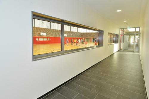 Durchblick in beide Richtungen: Platz für Zuschauer und Beaufsichtigungsmöglichkeit der Flure aus der Halle.